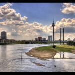 Ein Blick auf einen Fluss mit einer Brücke im Hintergrund in Düsseldorf II.