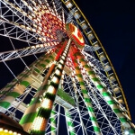 Ein großes Riesenrad in Düsseldorf ist nachts beleuchtet.