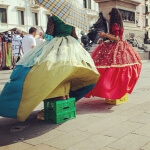 Zwei Frauen gehen in Venezia II mit einem Regenschirm eine Straße entlang.