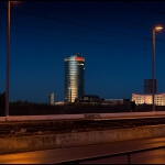 Eine Stadt bei Nacht mit einem hohen Gebäude zur blauen Stunde.