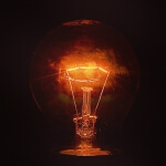 Vor einem dunklen Hintergrund leuchtet ein Licht auf.