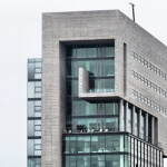 Ein hohes Gebäude im Düsseldorfer Medienhafen mit vielen Fenstern und Balkonen.