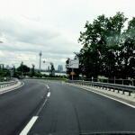 Ein Auto fährt auf einer Autobahn mit einer Brücke im Hintergrund in Düsseldorf.