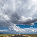 Eine leere Straße unter einem bewölkten Himmel, die zu einem Abenteuer einlädt.