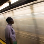 Ein Mann steht neben einem New Yorker U-Bahn-Zug.