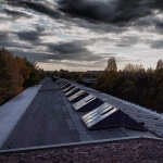 Das Dach eines Gebäudes in Berlin unter bewölktem Himmel.