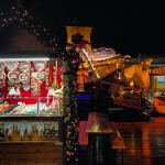 Ein Weihnachtsmarkt auf einem Dock in der Nacht.