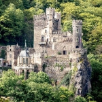 Die Burg Rheinstein liegt auf einem von Bäumen umgebenen Hügel in Deutschland.