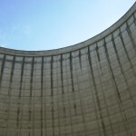 Eine gebogene Betonwand mit einem blauen Himmel im Hintergrund.