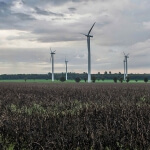 Windkraftanlagen auf einem Feld unter bewölktem Himmel liefern erneuerbare Energie.