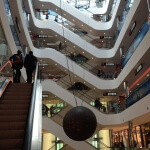 Ein Einkaufszentrum mit vielen Rolltreppen und einem großen Ball.