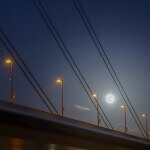 Über der Oberkasseler Brücke ist nachts der Vollmond zu sehen.