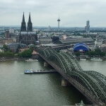 Ein Blick auf den Kölner Dom von der Spitze einer Brücke aus, der den Kölner Himmel zeigt.