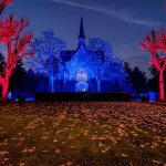 Eine in rotem und blauem Licht erleuchtete Kirche auf dem Nordfriedhof in Düsseldorf.