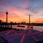 Der Rhein-Sonnenuntergang wirft seinen Schein über einen Fluss.