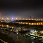 Boote legten nachts in der Nähe einer Brücke in Düsseldorf an.