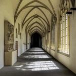 Ein langer Flur im Münsteraner Dom mit Bögen und Fenstern.