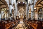 Das Innere der Christ Church Cathedral in Oxford mit Holzbänken und einer verzierten Decke.