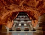 In einer U-Bahn-Station führen Rolltreppen nach oben; die Wände und die Decke sehen aus wie Naturgestein und werden von künstlichem Licht beleuchtet.